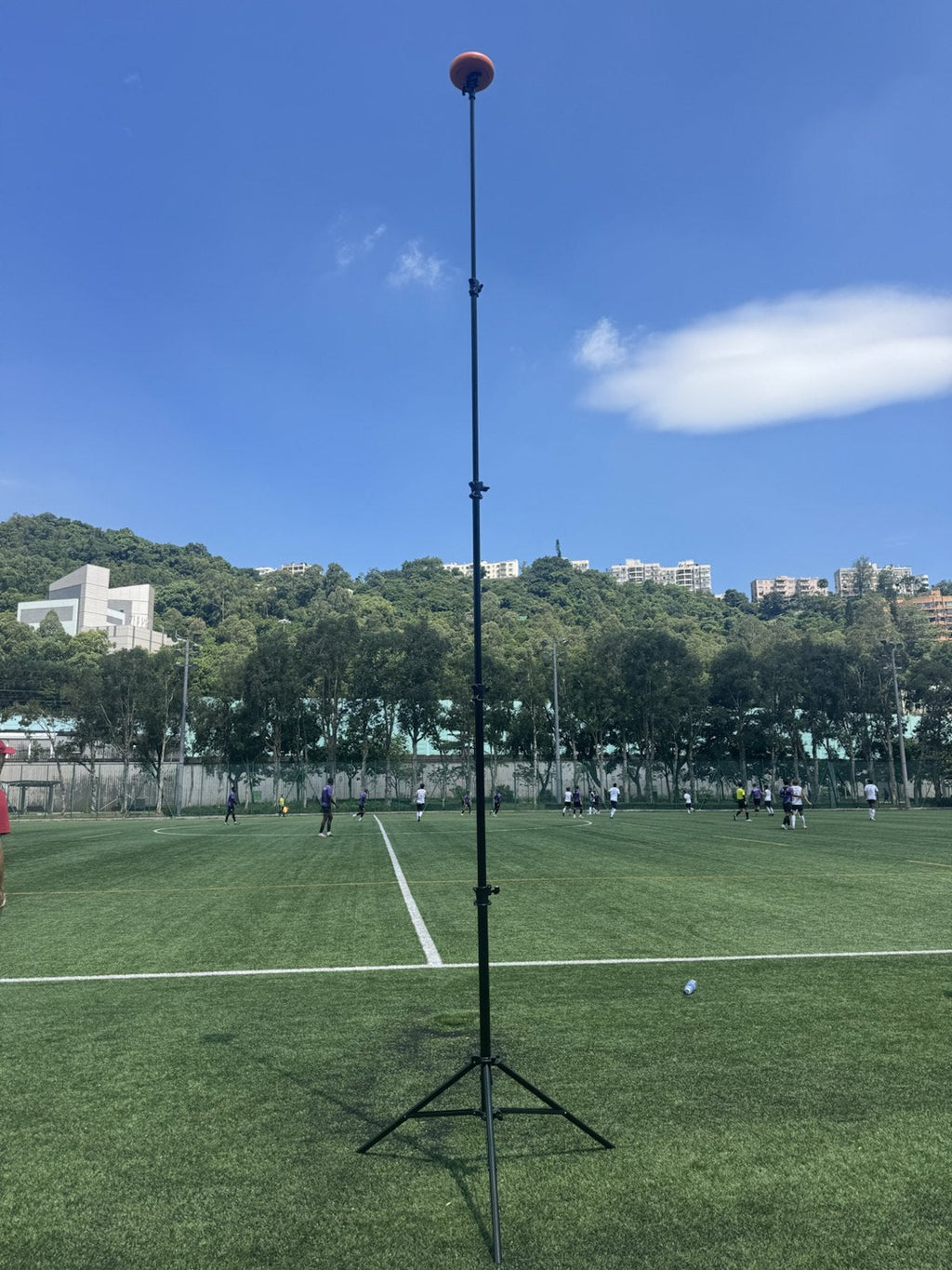 Ballr AI Sports Camera on the fully extended 4.8m tripod at the side of a football pitch during a match